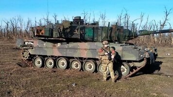 ein-russischer-soldat-zeigt-sich-vor-dem-zurueckgelassenen-leopard-2-in-der-ostukraine.jpg